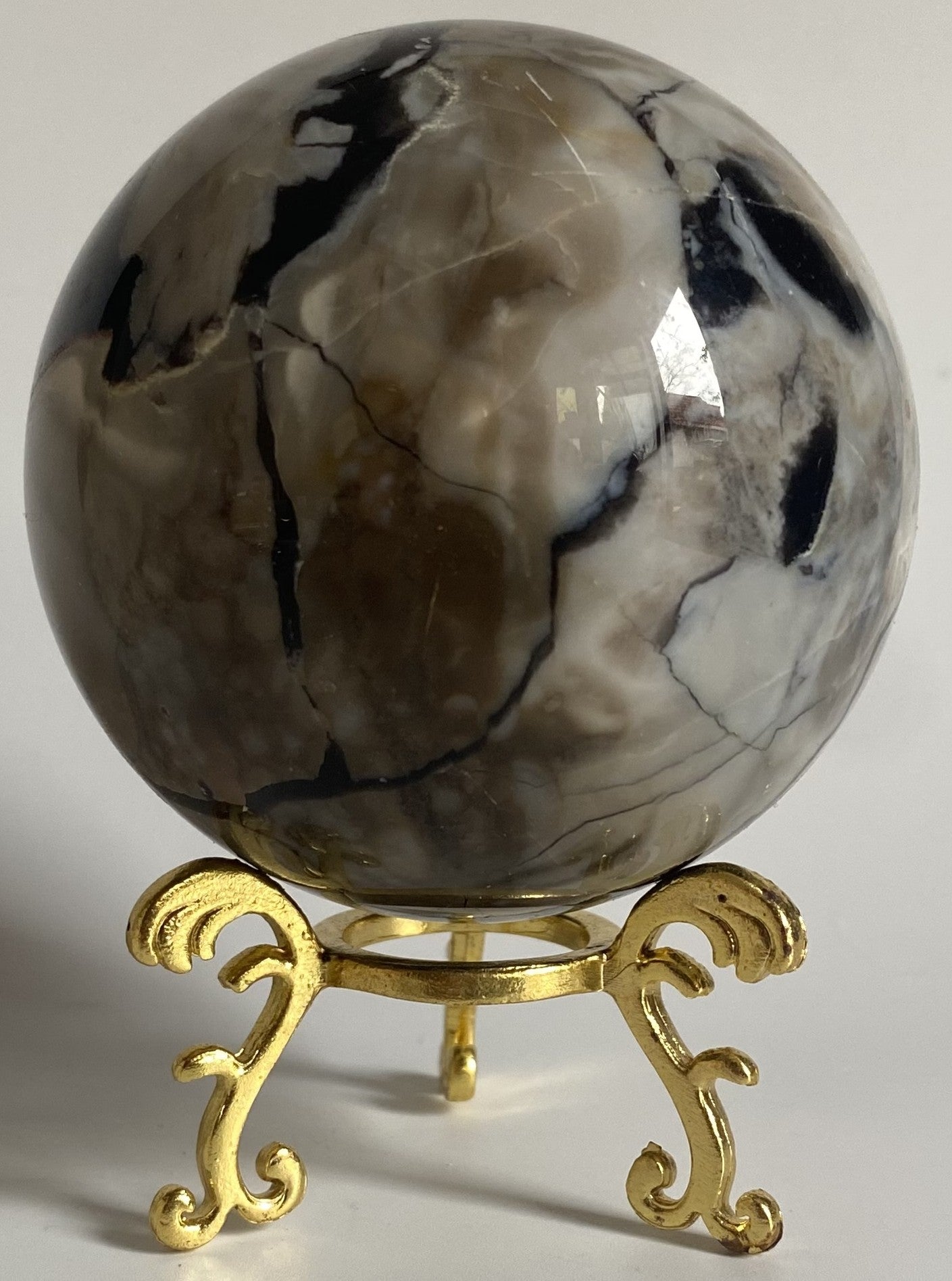 Sfera din cristal de agat vulcanic pe suport metalic cu fundal alb