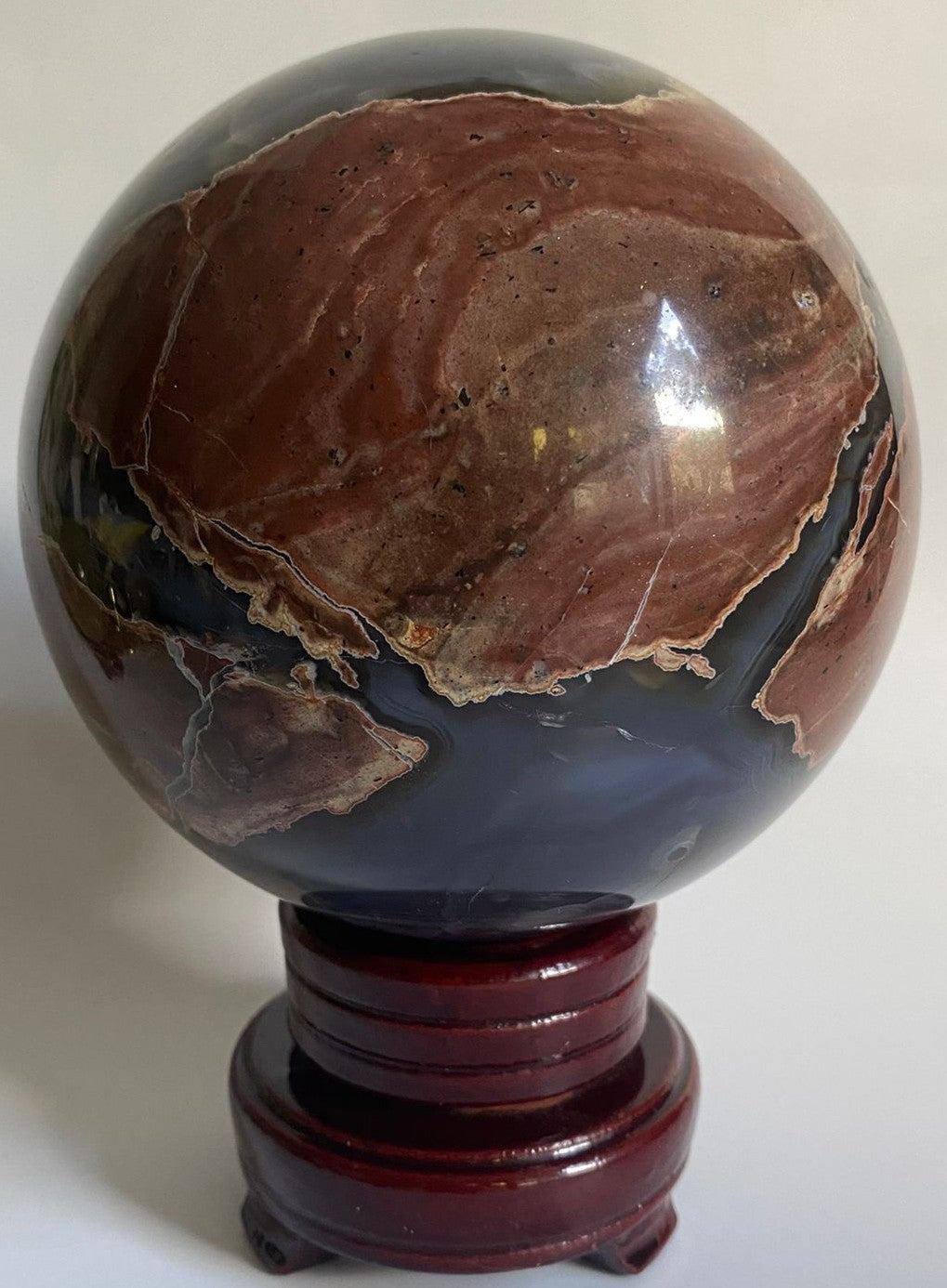 Sfera de 11.7cm din mineral de agat vulcanic pe suport din lemn cu fundal alb