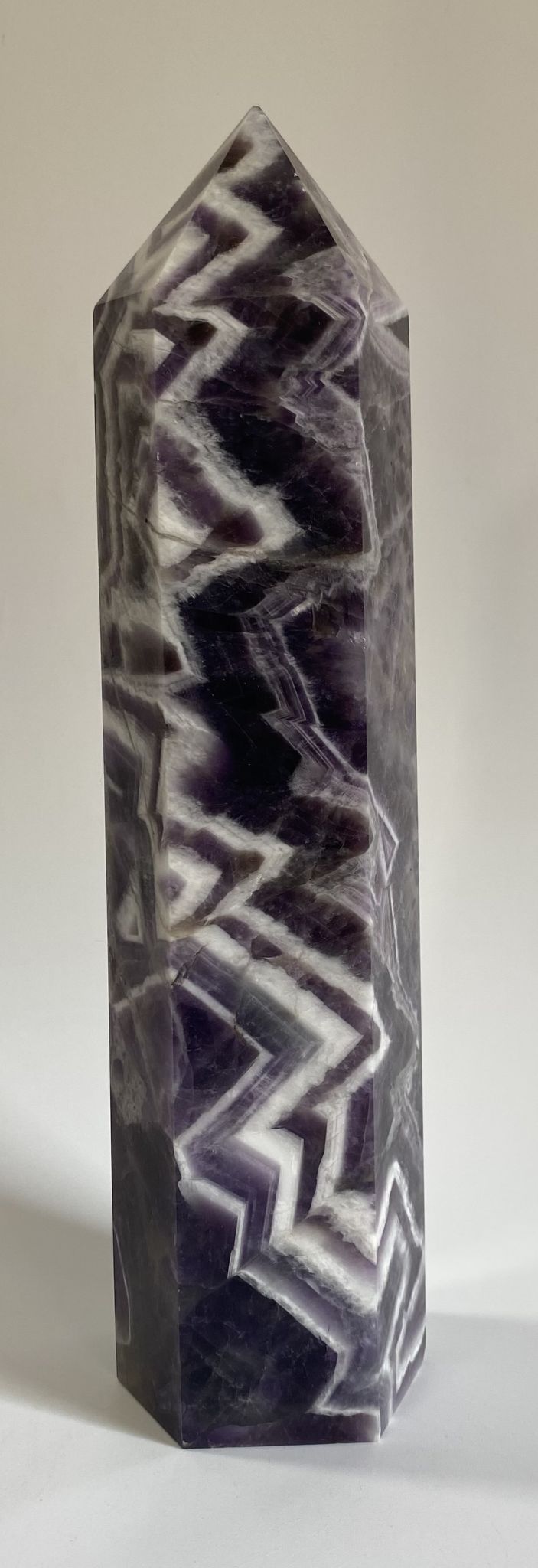 Obelisc din cristal de ametist chevron pe fundal alb
