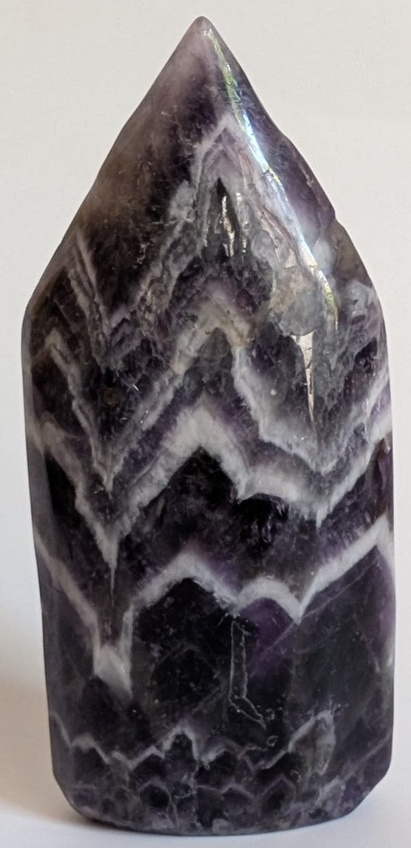 Sculptura din piatra semipretioasa de ametist chevron pe fundal alb