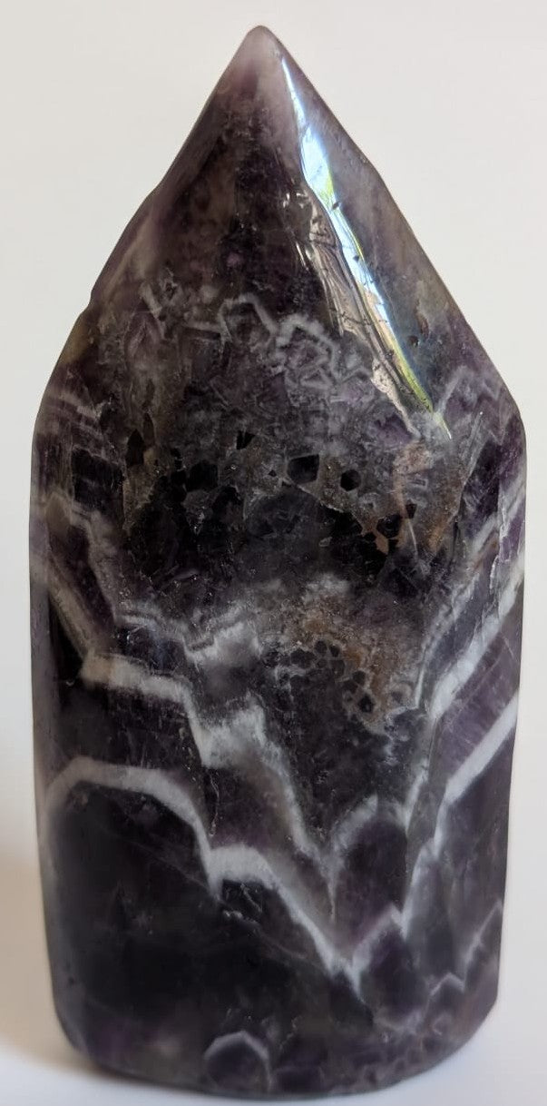 Sculptura din cristal de ametist chevron pe fundal alb
