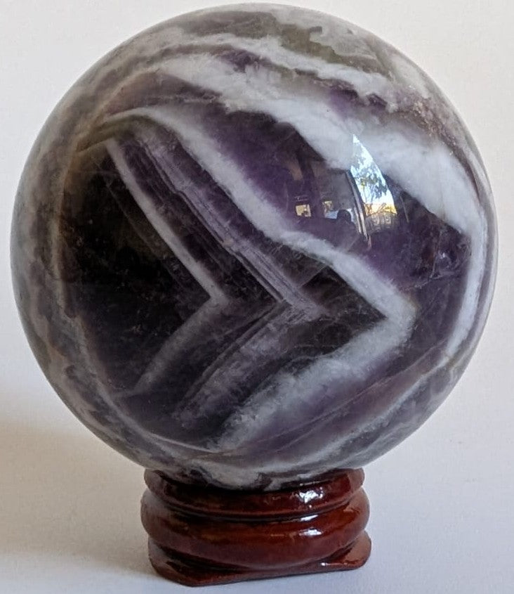 Sfera din cristal de ametist chevron pe suport din lemn cu fundal alb