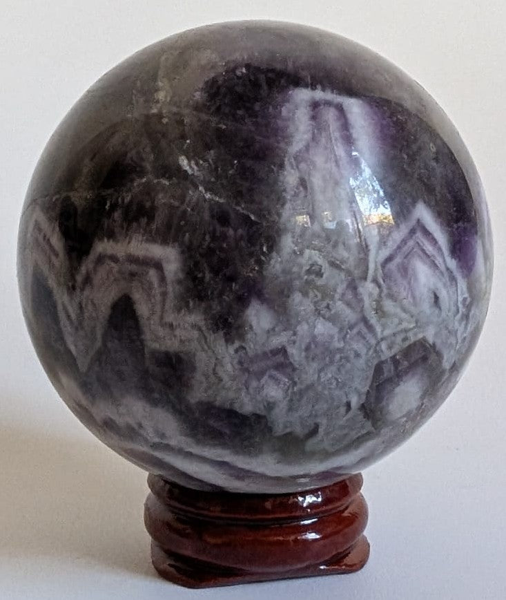 Sfera de 5.9cm din piatra semipretioasa de ametist chevron pe suport din lemn cu fundal alb