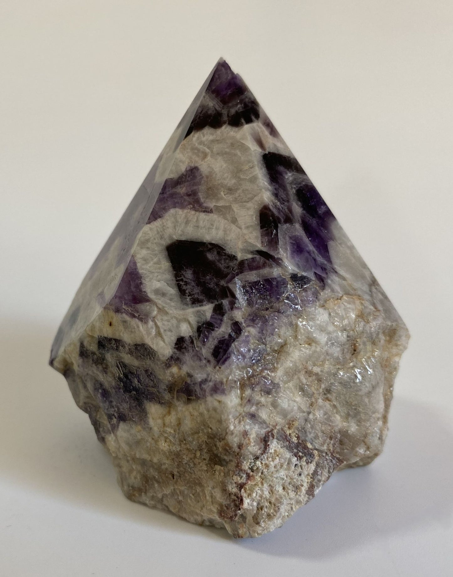 Varf polisat din cristal de ametist chevron pe fundal alb