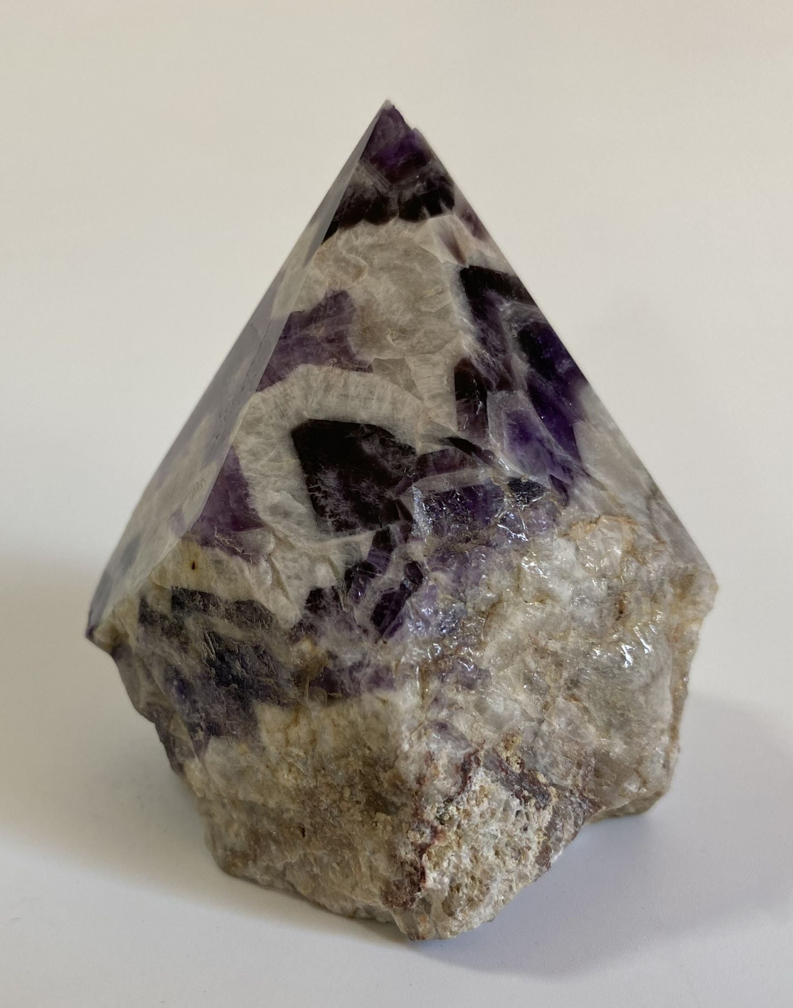 Varf polisat din cristal de ametist chevron pe fundal alb