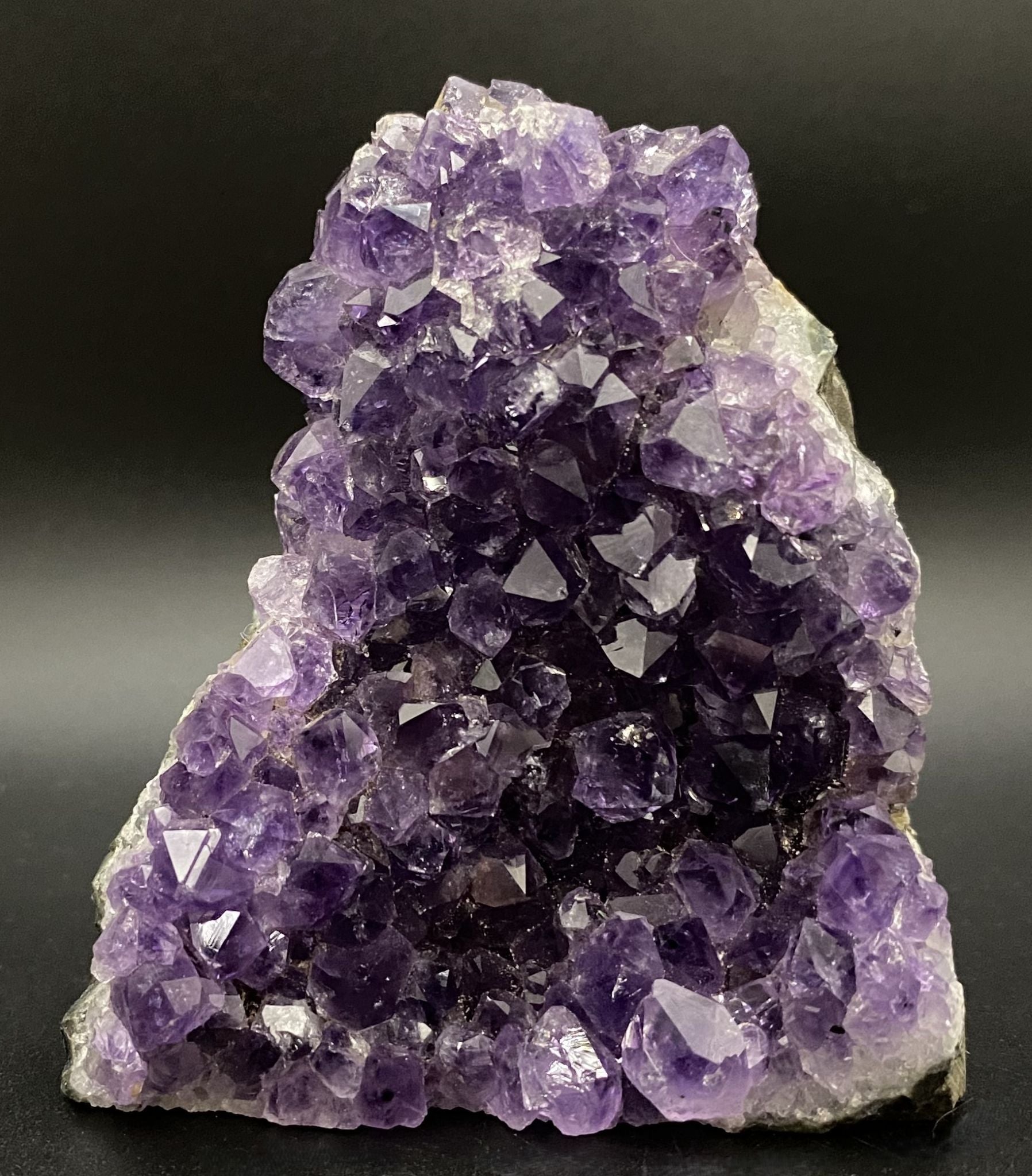 Fragment de geoda din piatra semipretioasa de ametist pe fundal negru