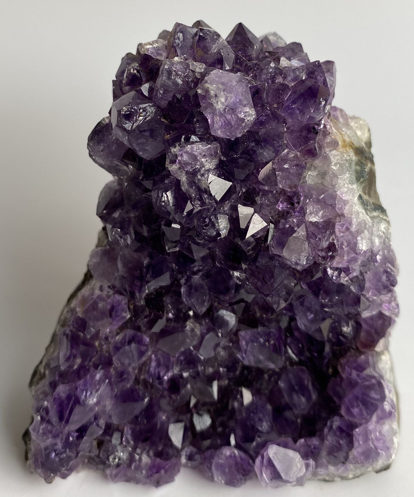 Fragment de geoda din piatra semipretioasa de ametist pe fundal alb