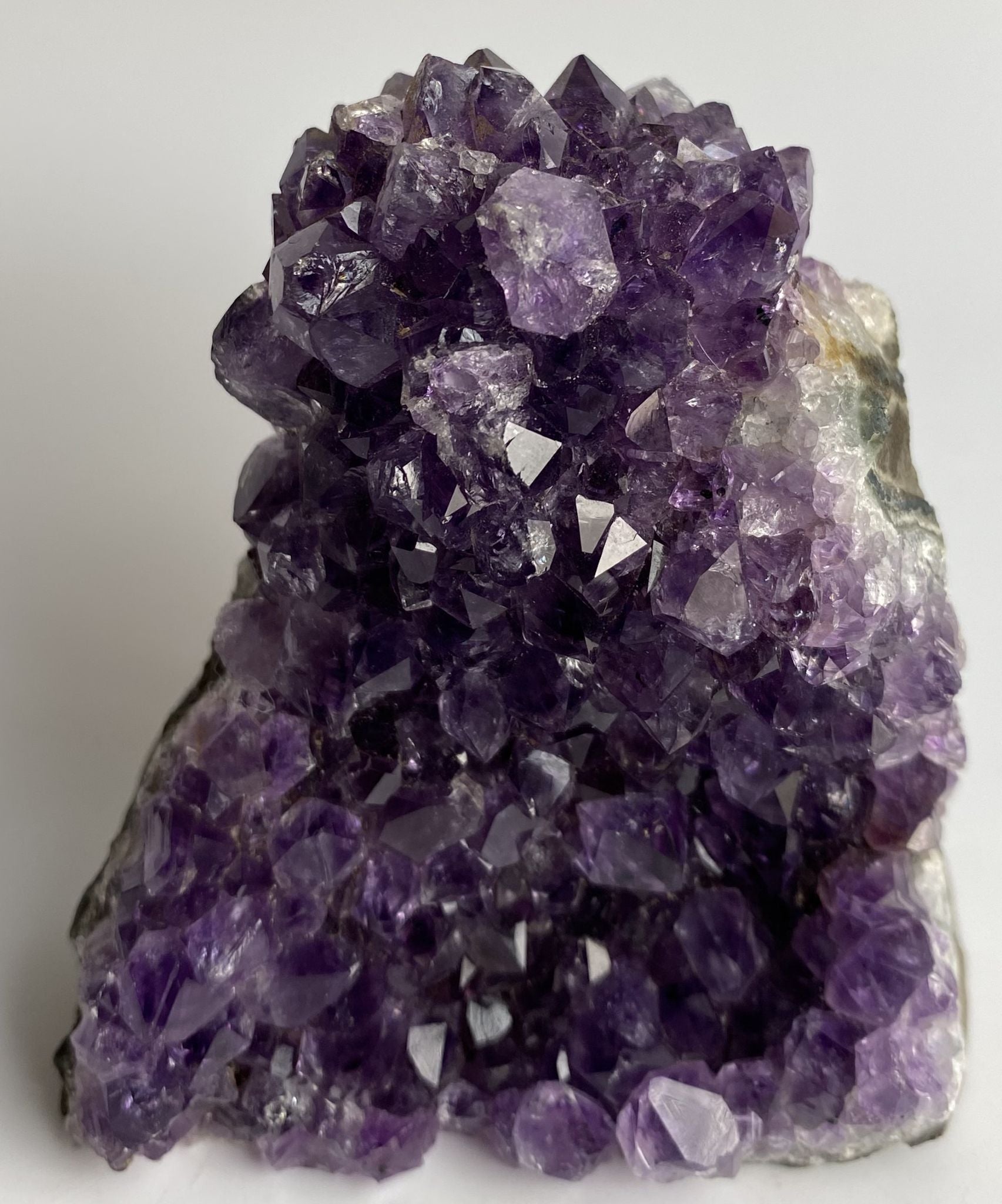 Fragment de geoda din piatra semipretioasa de ametist pe fundal alb