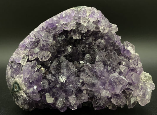 Fragment geoda din piatra semipretioasa de ametist pe fundal negru