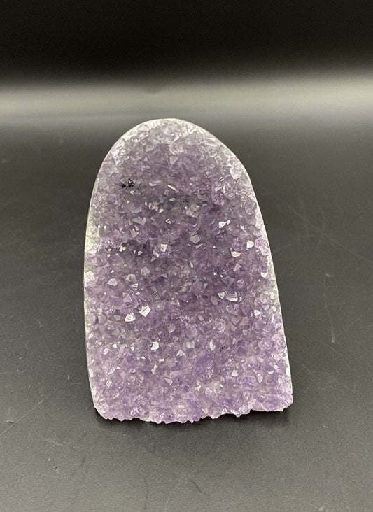 Geoda din Ametist piatra semipretioasa mov cu cristale stralucitoare pe fundal negru