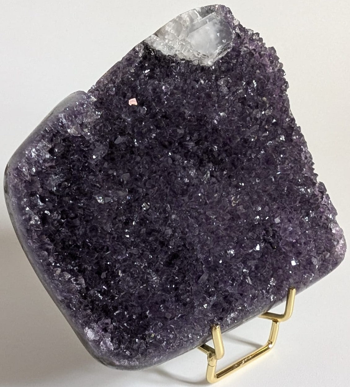 Fragment geoda din cristal de ametist pe suport metalic pe fundal alb