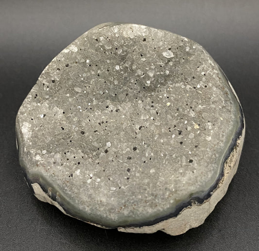 Geoda din ametist negru pe fundal negru sub lumina artificiala