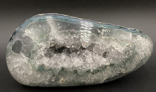 Geoda din ametist negru pe fundal negru sub lumina artificiala