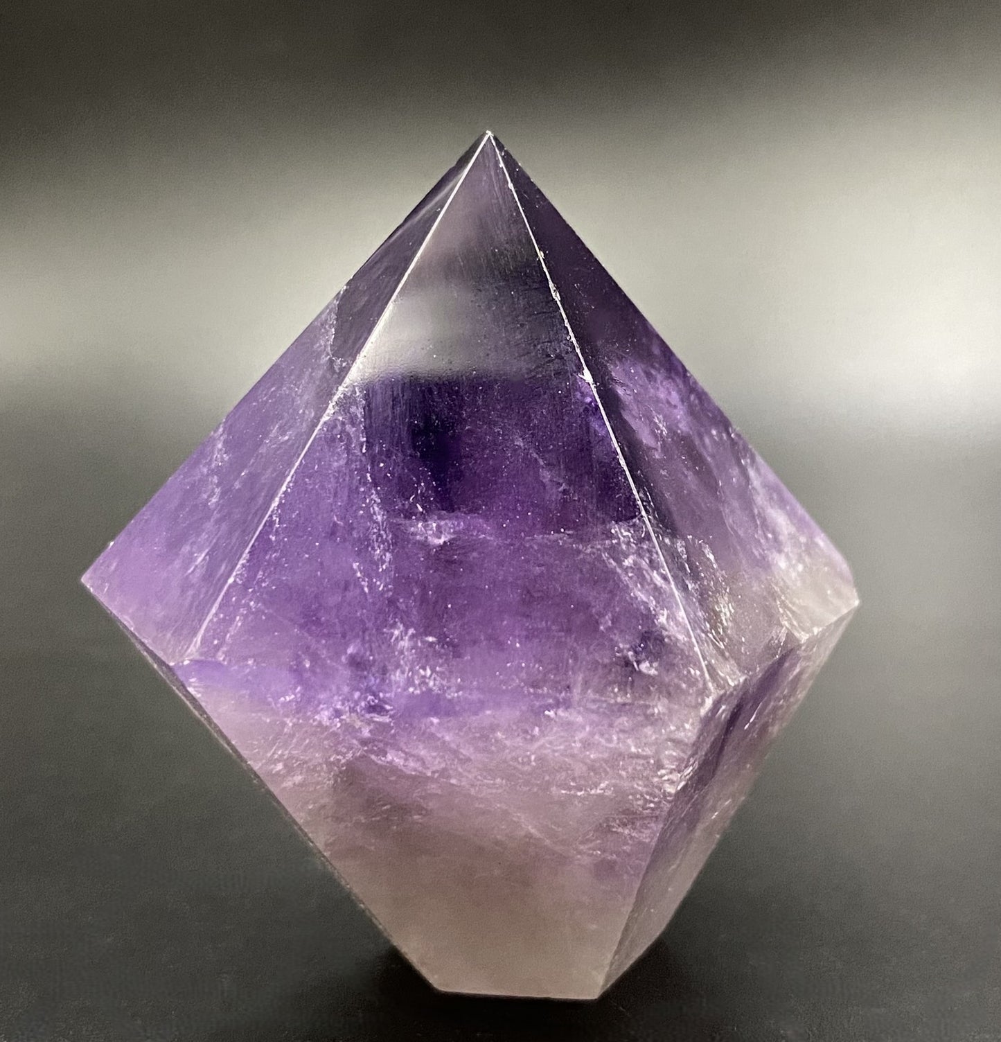 Obelisc din piatra semipretioasa de ametist pe fundal negru