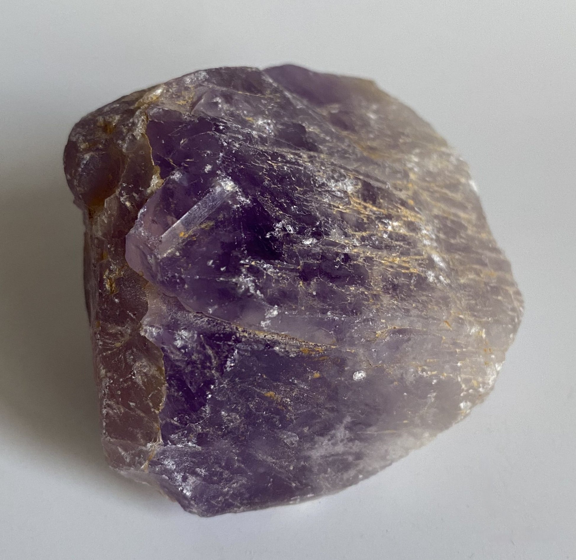 Piatra bruta din cristal natural de ametist pe fundal alb