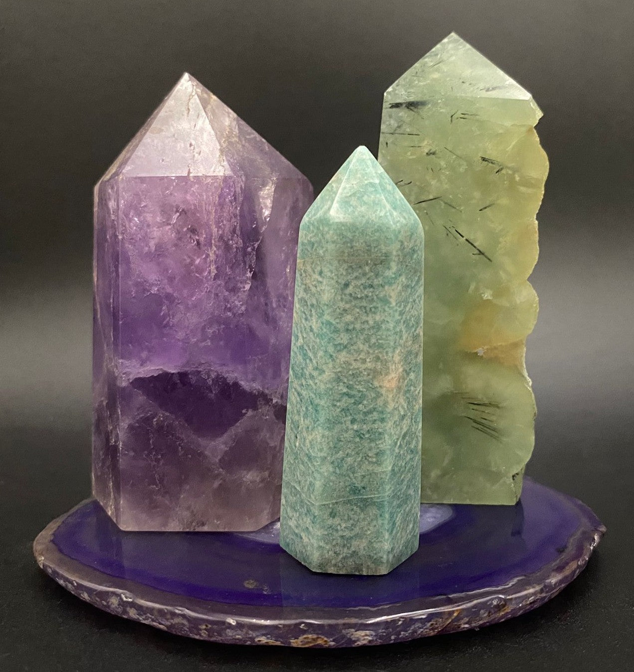 Set decorativ cu cristale din ametist, prehnit si amazonit pe felie de agat mov cu fundal negru