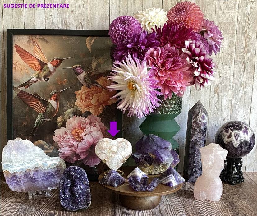 Inima din ametist roz de 9.1cm pe suport metalic cu cristale semiprețioase naturale lângă flori roz și aranjament decorativ