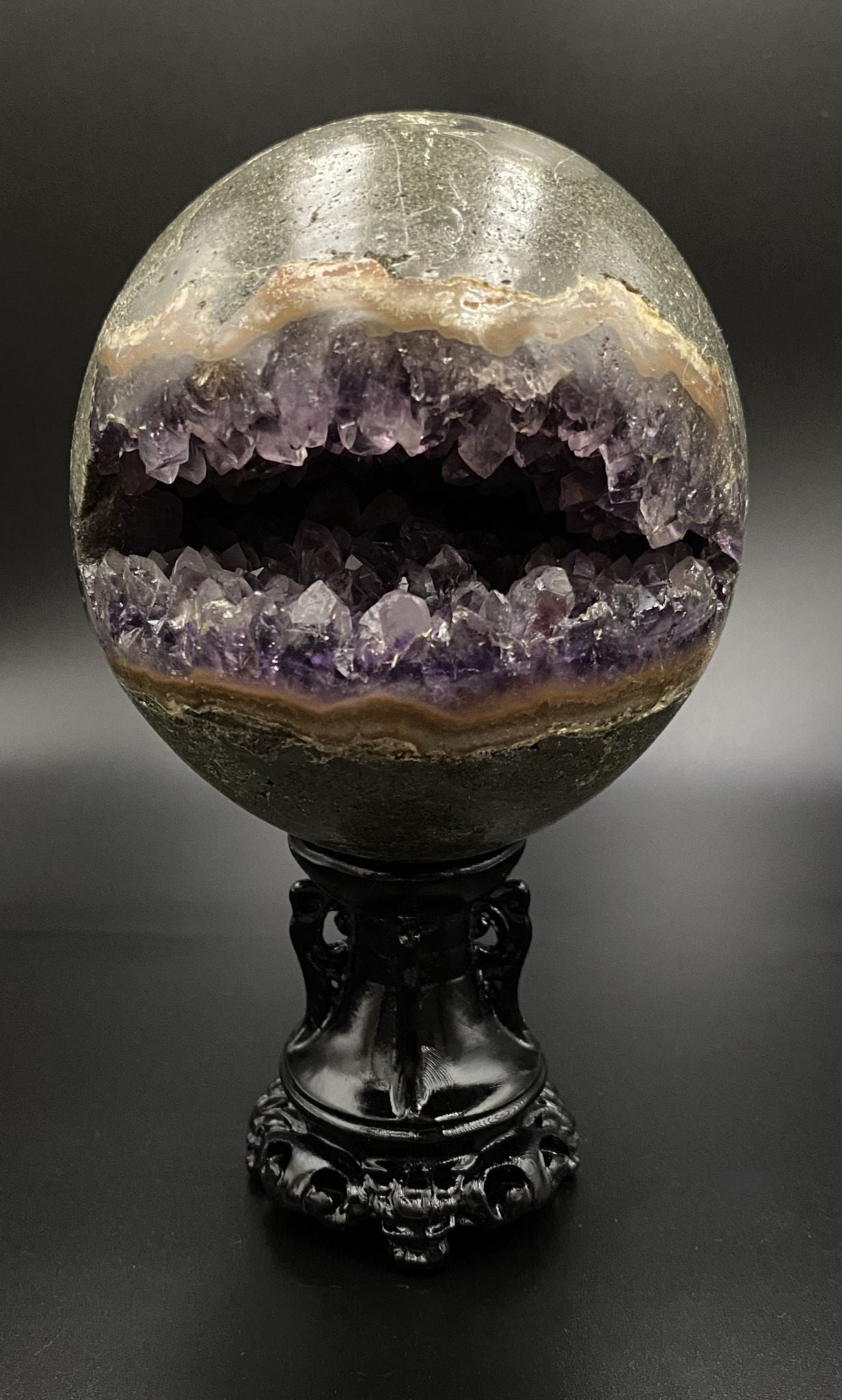 Sfera din geoda de piatra semipretioasa de ametist pe suport decorativ cu fundal negru