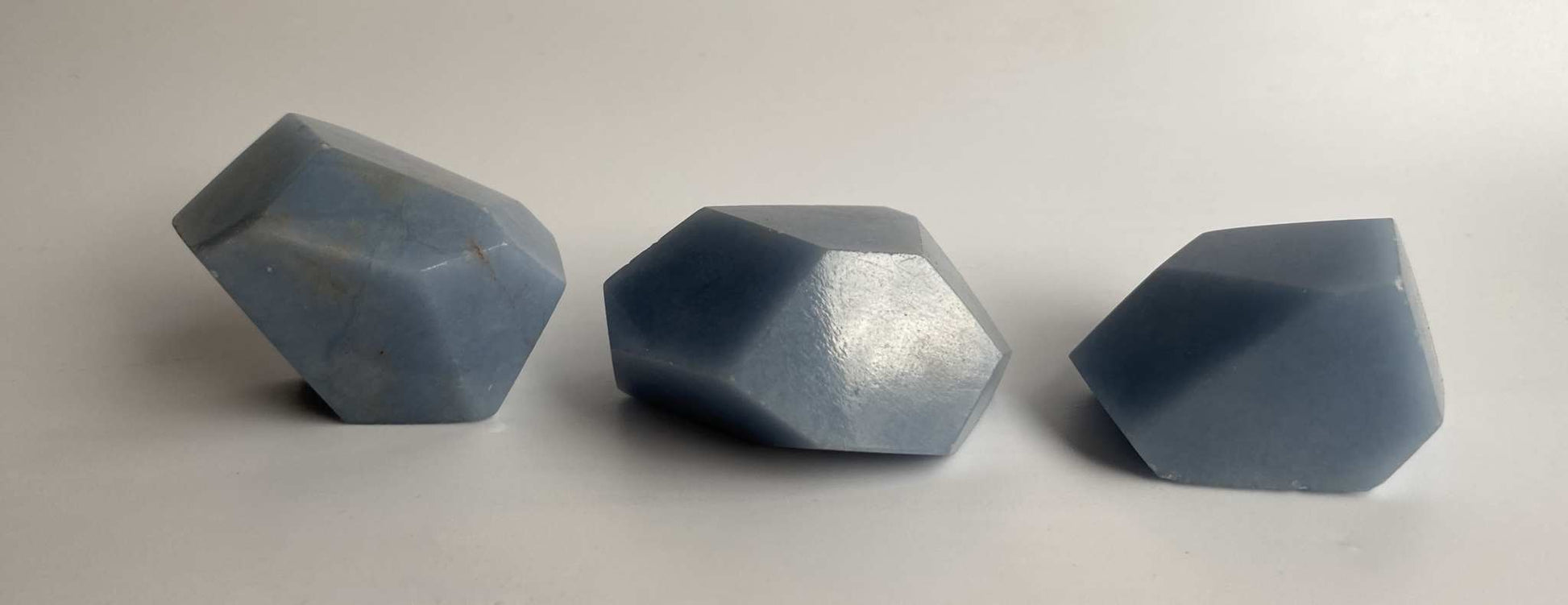 Set forme poligonale din Angelit albastru, trei forme geometrice lustruite pe fundal alb.