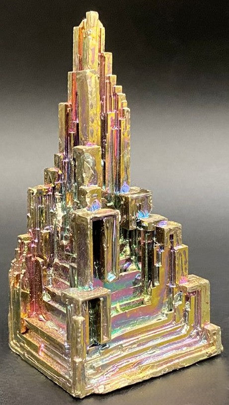 Specimen piramidal din piatra semipretioasa de bismut pe fundal negru
