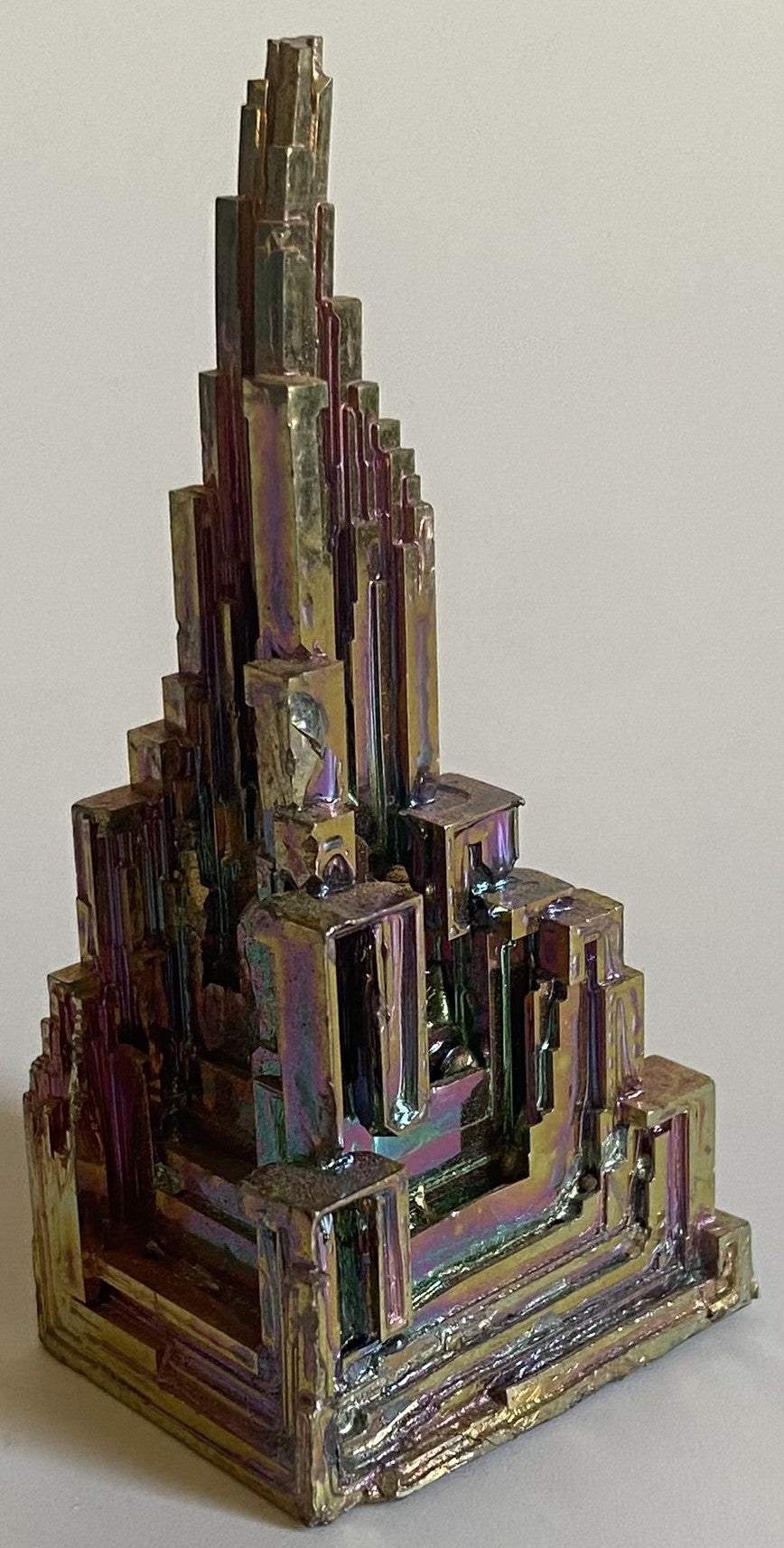 Specimen piramidal din piatra semipretioasa de bismut pe fundal alb