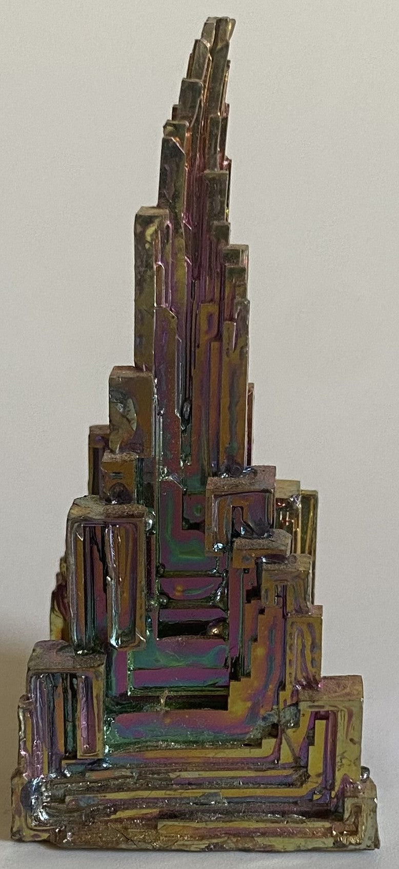 Specimen piramidal din cristal de bismut pe fundal alb