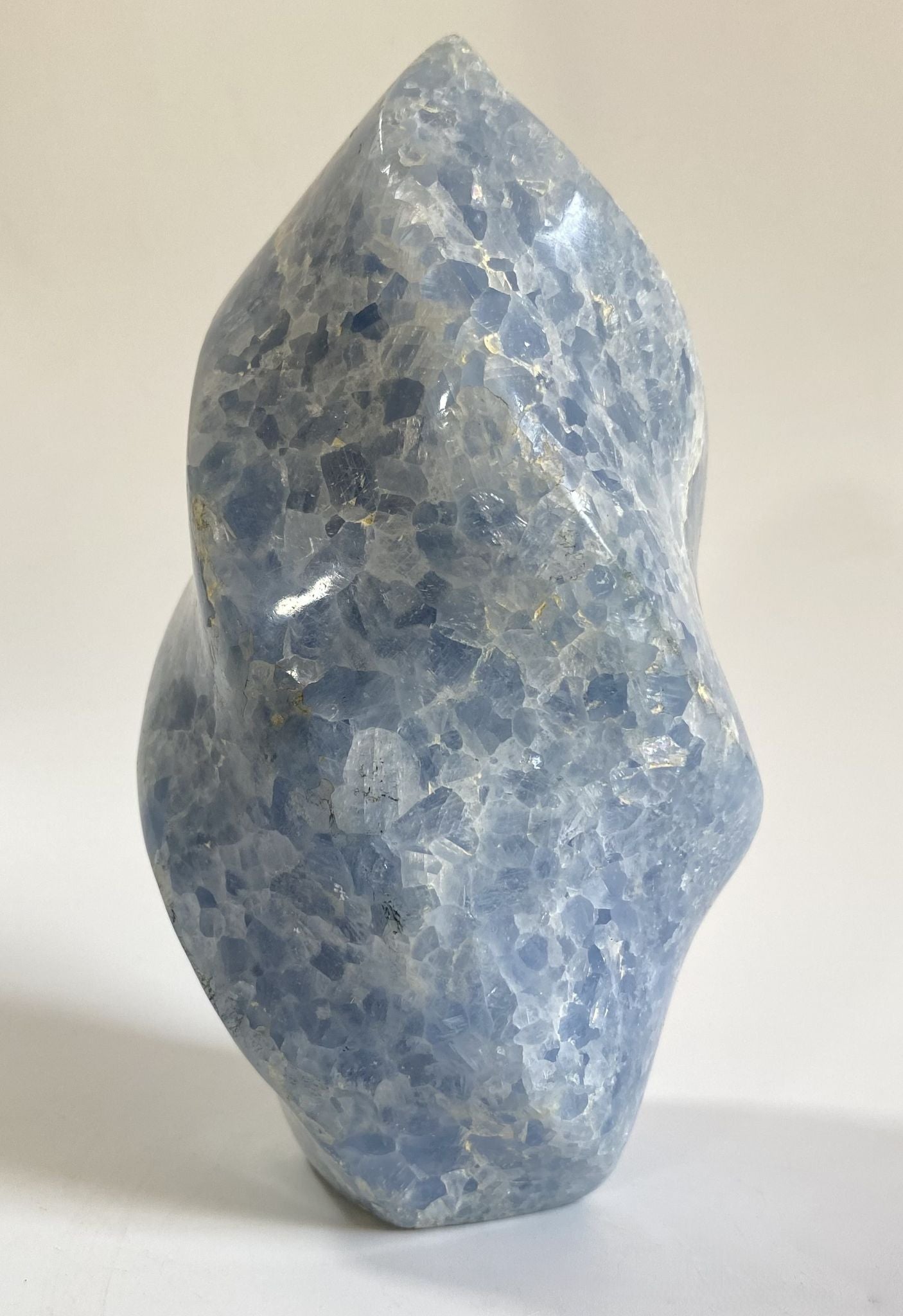 Sculptura din cristal de calcit albastru pe fundal alb