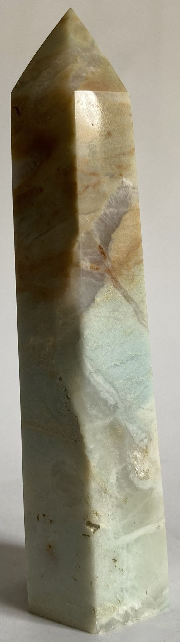 Obelisc din cristal de calcit caraibe albastru pe fundal alb