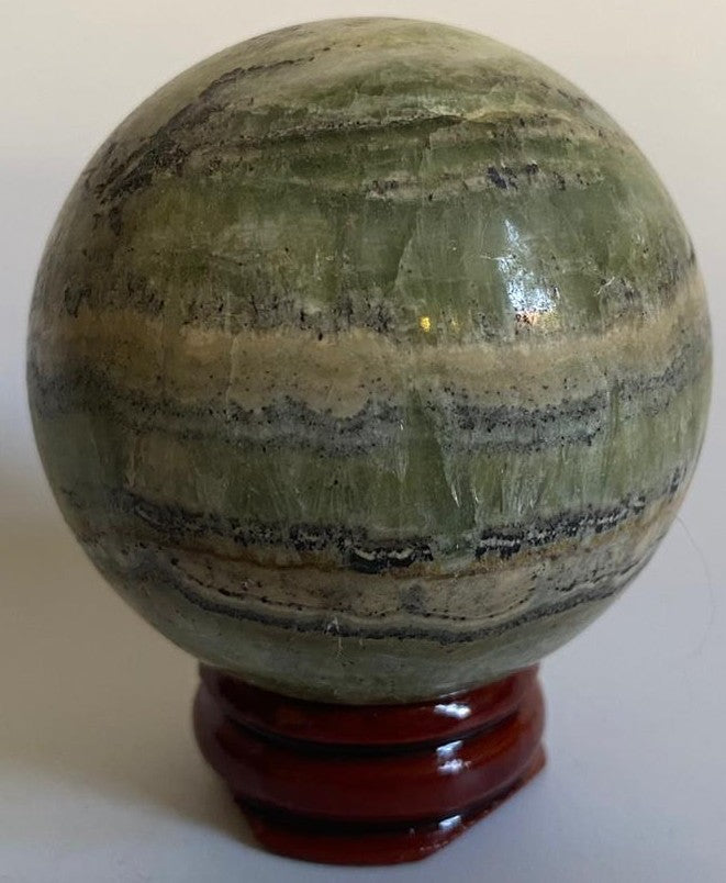 Sfera de 5.3cm din piatra semipretioasa de calcit caraibe verde pe suport din lemn cu fundal alb