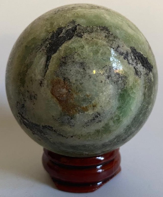 Sfera de 5.3cm din cristal de calcit caraibe verde pe suport din lemn cu fundal alb