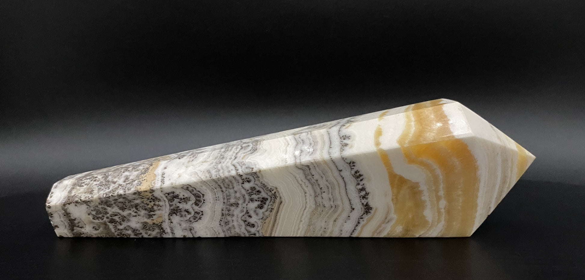 Obelisc sceptru din mineral de calcit dendritic pe fundal negru sub lumina artificiala