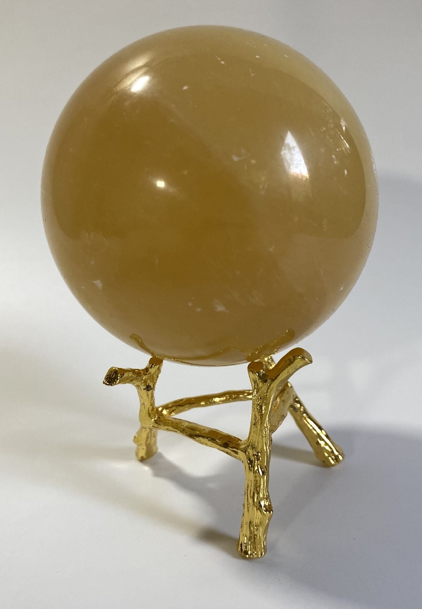 Sfera de 6.9cm din piatra semipretioasa de calcit galben pe suport metalic cu fundal alb