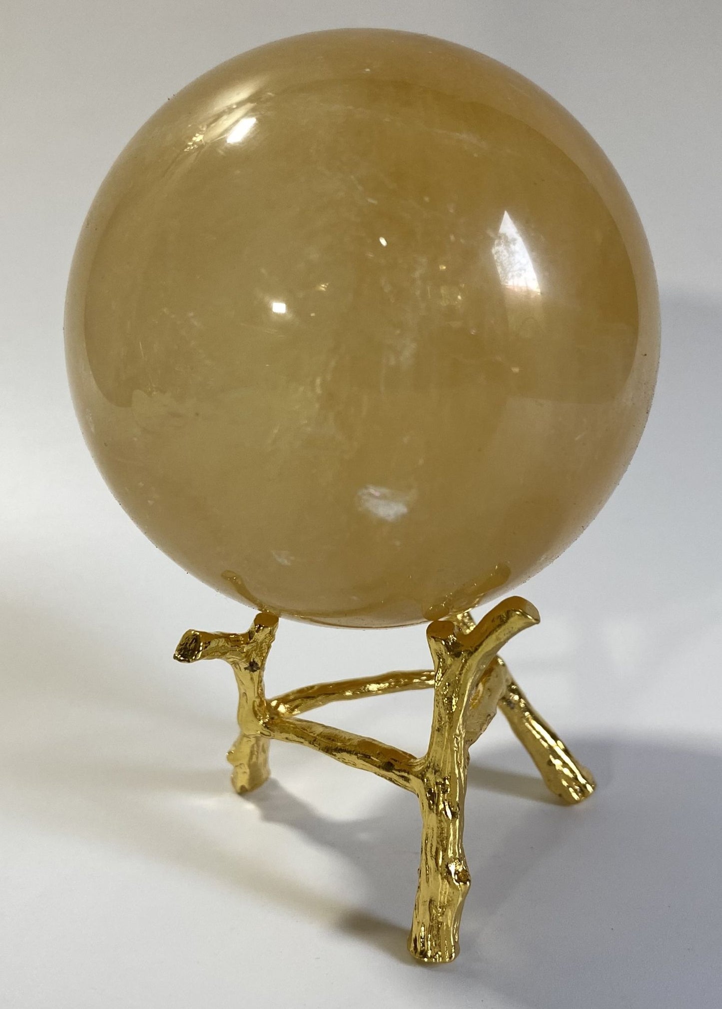 Sfera decorativa de 6.9cm din piatra semipretioasa de calcit galben pe suport metalic cu fundal alb