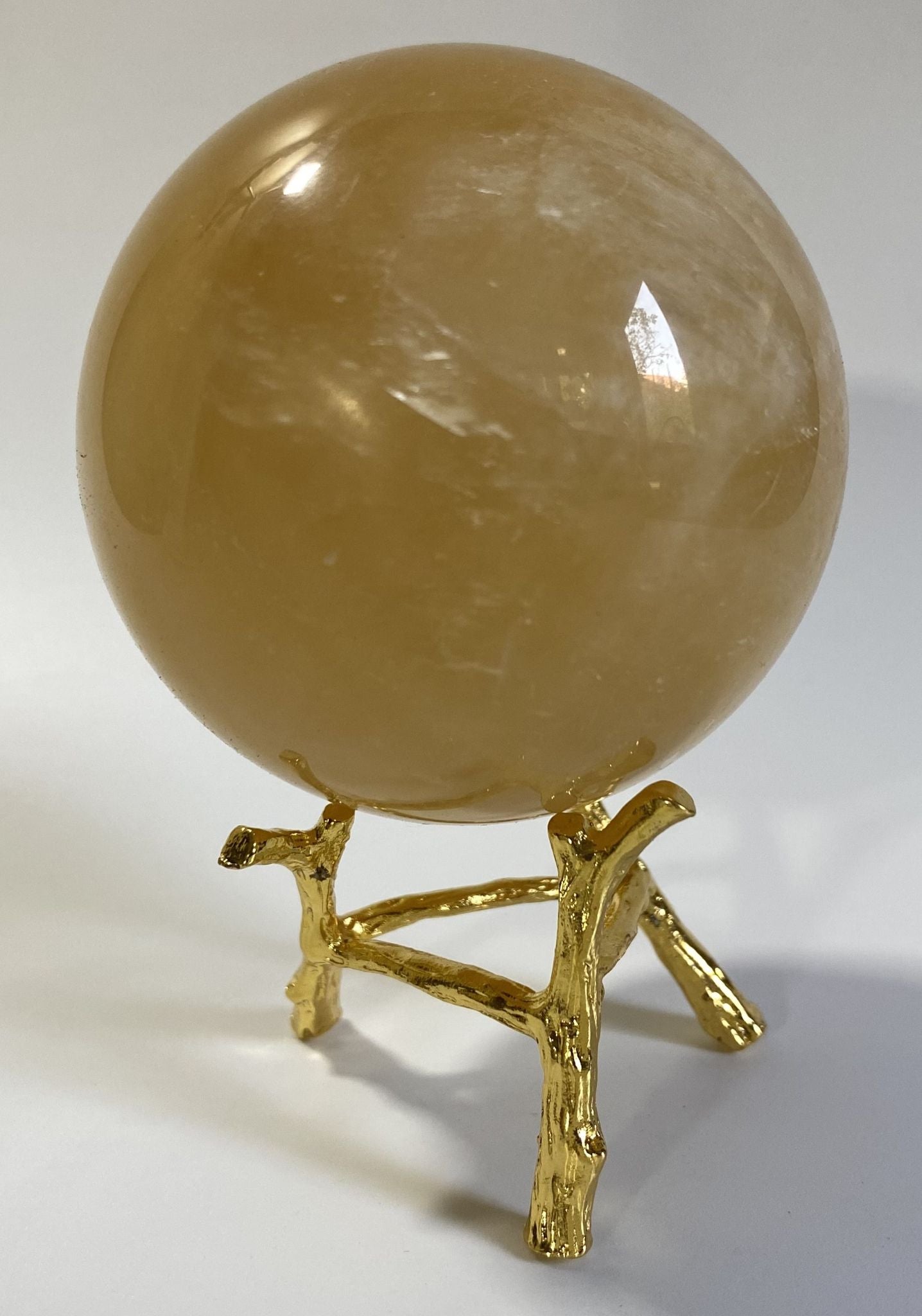 Sfera decorativa de 6.9cm din cristal de calcit galben pe suport metalic cu fundal alb