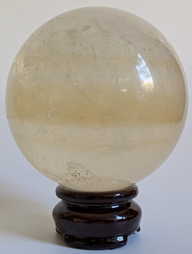 Sfera din cristal de calcit Islanda pe suport din lemn cu fundal alb