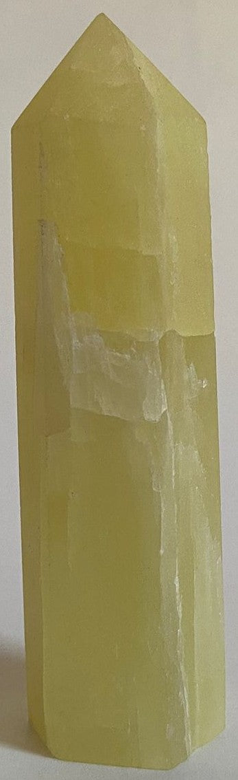 Obelisc din cristal de calcit lemon pe fundal alb