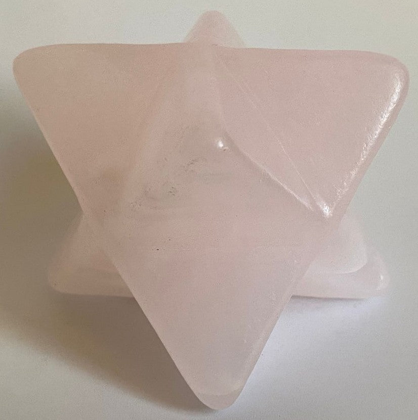 Merkaba din cristal de calcit roz pe fundal alb