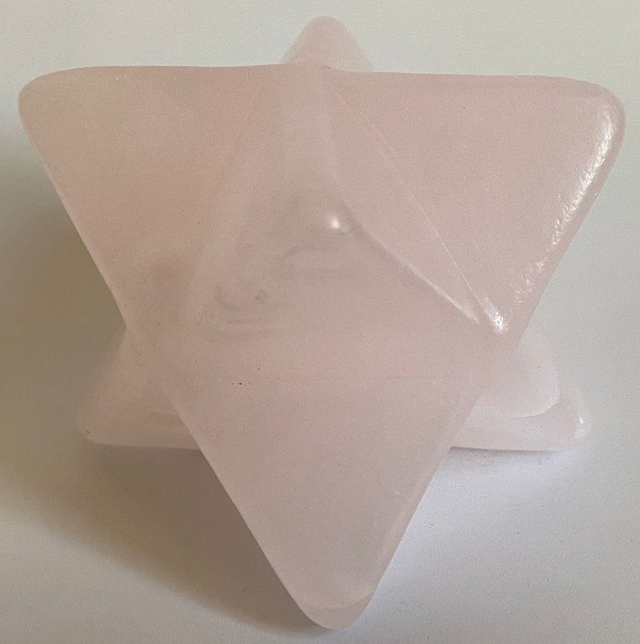 Merkaba din mineral de calcit roz pe fundal alb