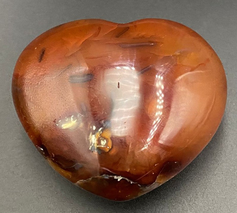 Inima din piatra semipretioasa de carneol pe fundal negru