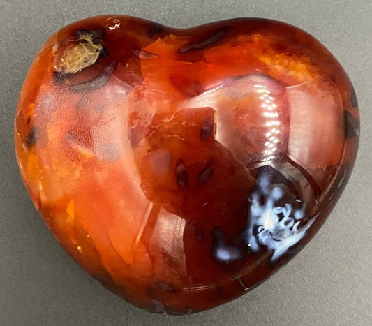 Inima din piatra semipretioasa de carneol pe fundal negru