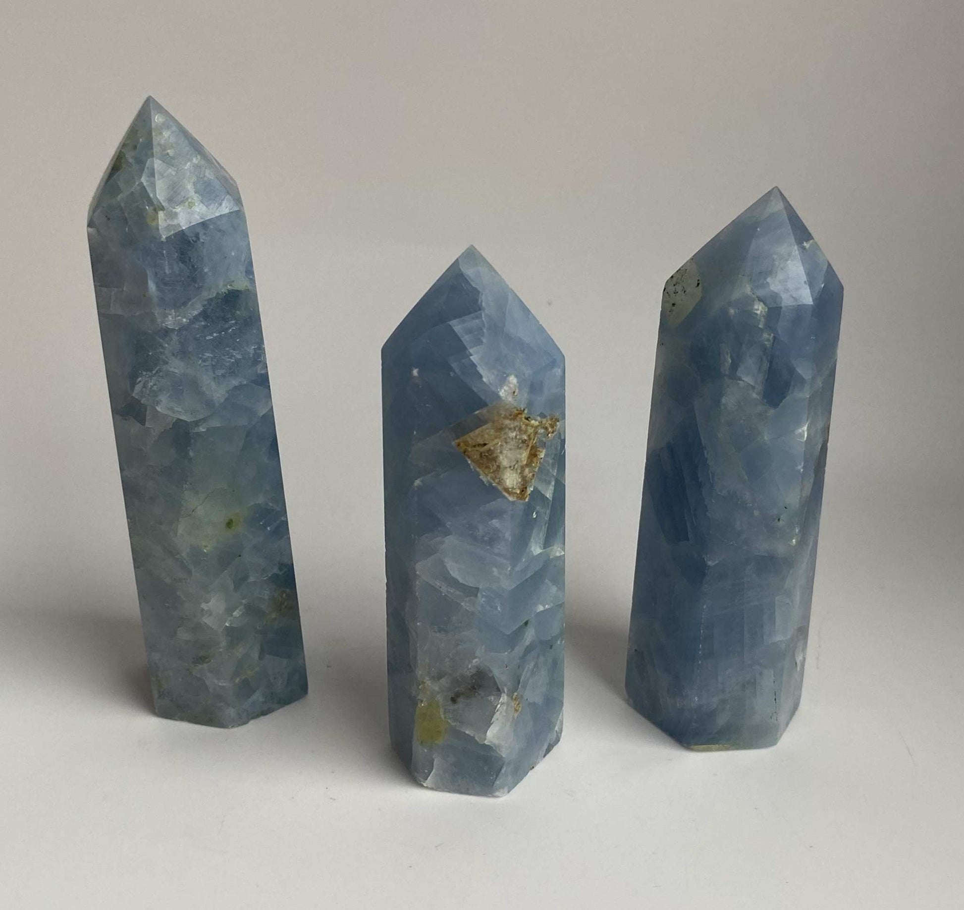 Set of three blue calcite obelisks semi-precious stones on white background