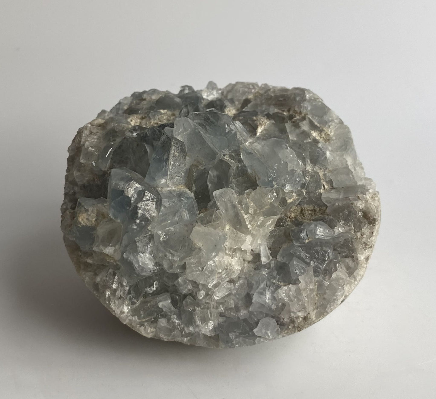 Geoda decorativa de 6.8cm din cristal de celestina pe fundal alb