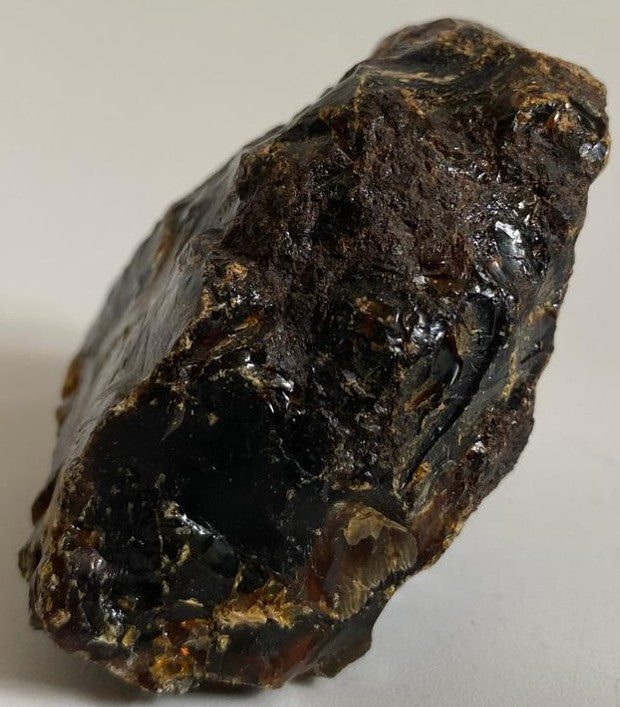 Piatra bruta de 5.9cm din piatra semipretioasa de ambra pe fundal alb