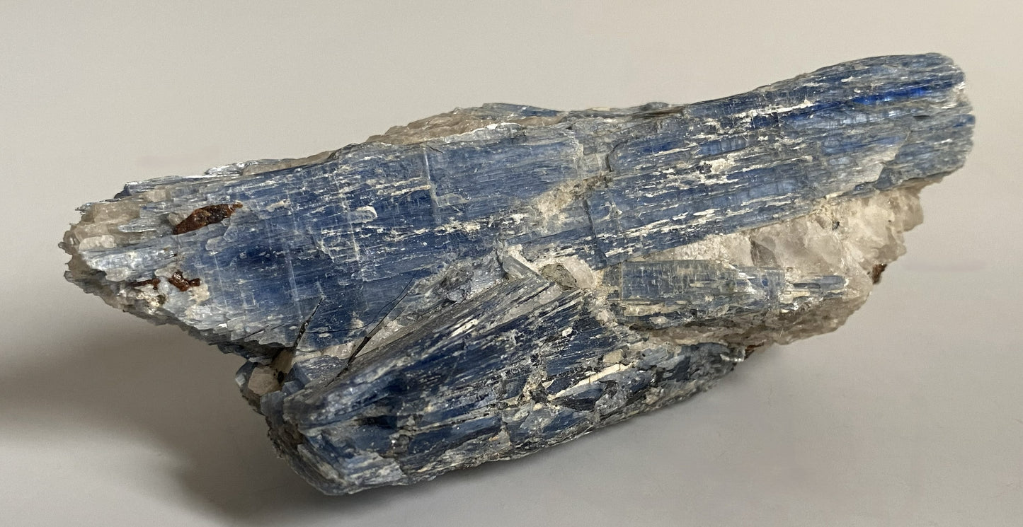Piatra bruta de 12.5cm din cristal de cianit pe fundal alb