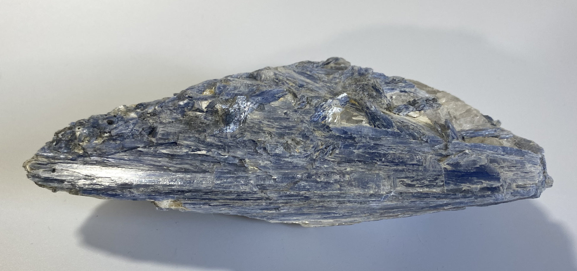 Piatra bruta din mineral de cianit pe fundal alb sub lumina naturala