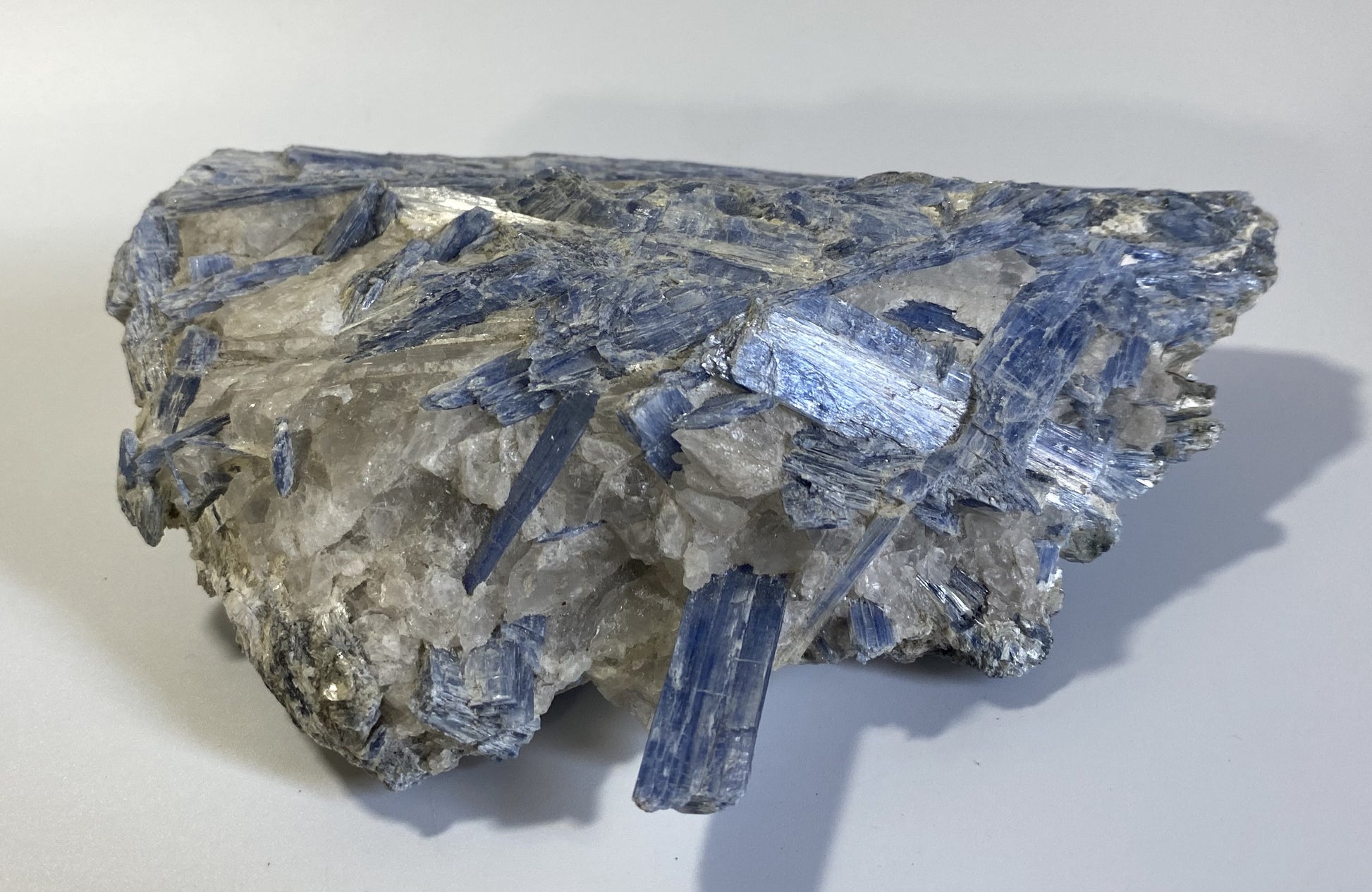 Piatra bruta din mineral de cianit pe fundal alb sub lumina naturala