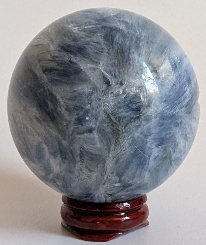 Sfera din cristal de cianit pe suport din lemn cu fundal alb