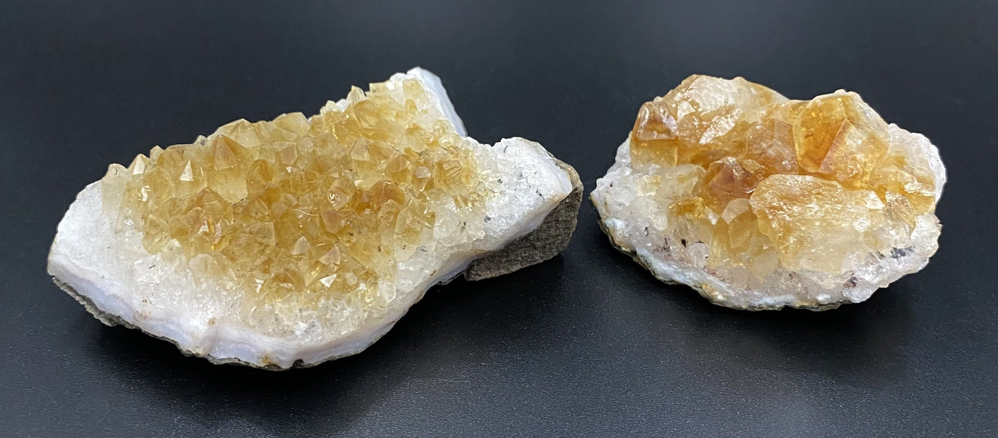 Doua fragmente de geoda de citrin pe fundal negru sub lumina artificiala