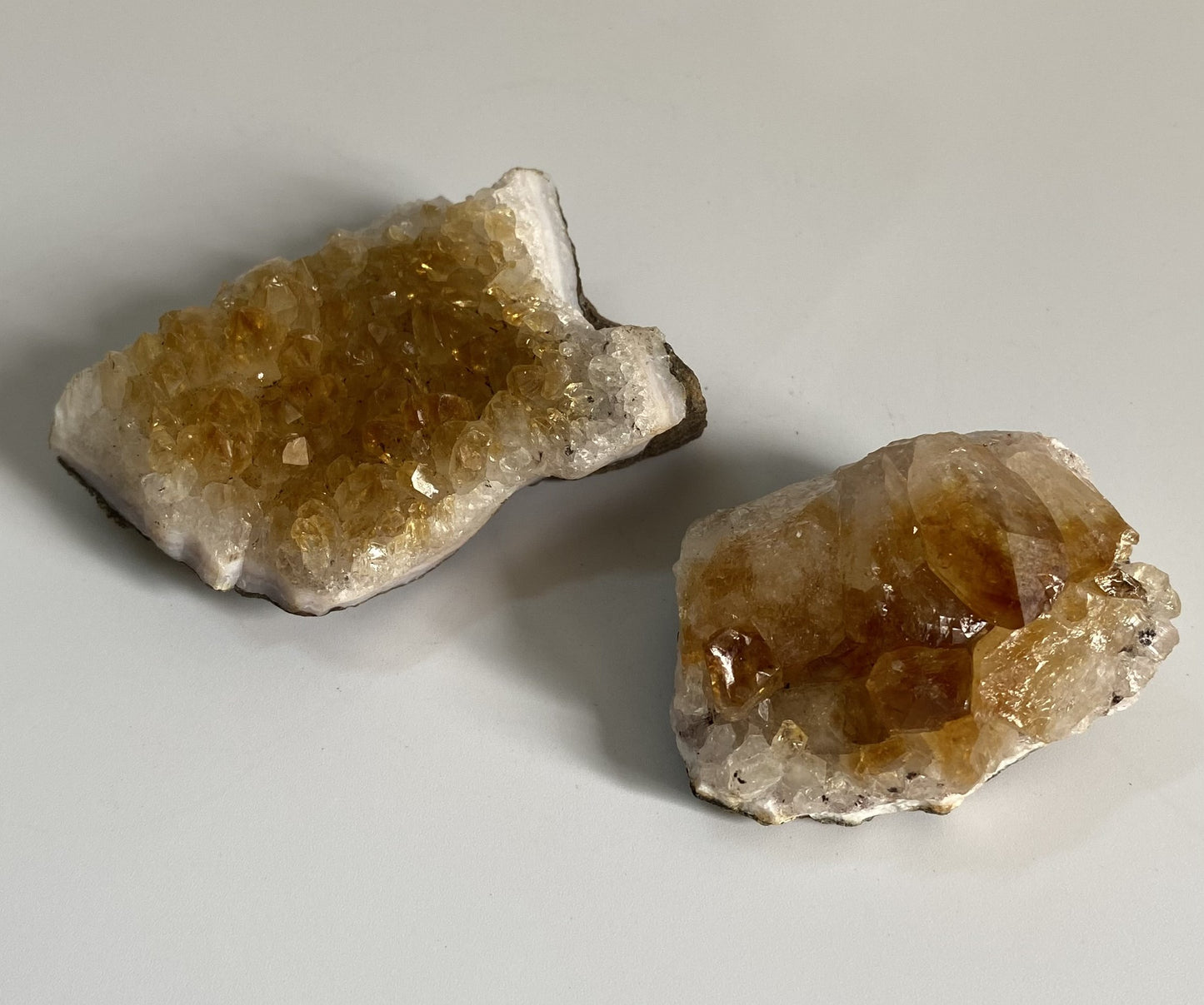 Doua fragmente de geoda de citrin pe fundal alb sub lumina naturala