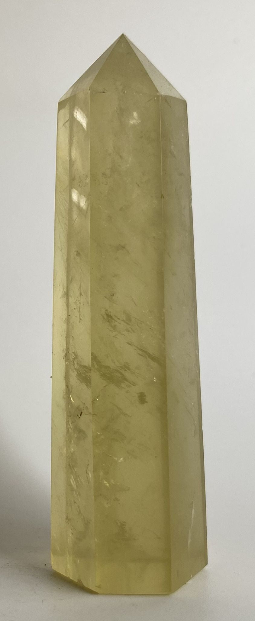 Obelisc din piatra semipretioasa de citrin pentru meditatie pe fundal alb